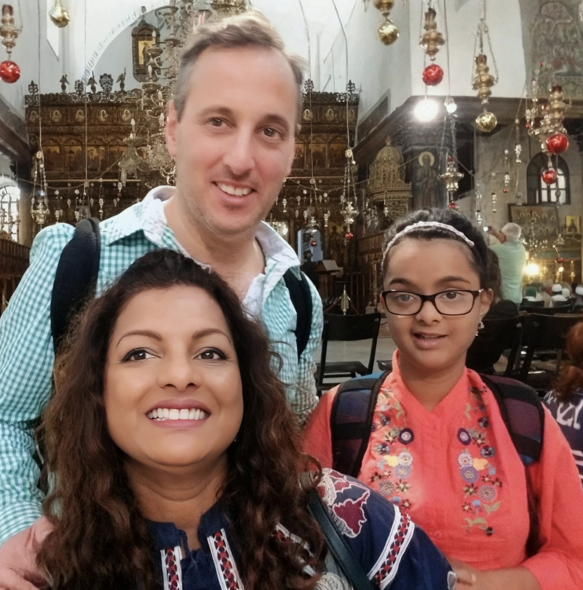 Rebecca, her partner, and Danielle together inside a historic church.
